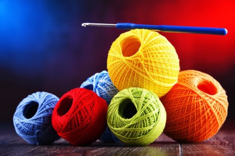 Composition with assortment of different colored yarns and hook for crocheting