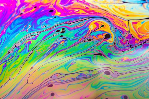 Abstract background made from soap bubble reflecting light. Rainbow soap bubble on a dark
