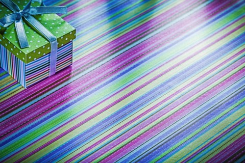 Cardboard box with ribbon on striped tablecloth celebration concept
