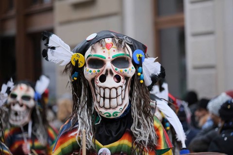 Colourful skull masks with decorative feathers in an exuberant parade