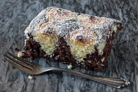 Coconut cake on a marble plate with silver fork