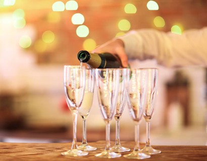Champagne glasses on wooden table in bright lights. Party or celebration