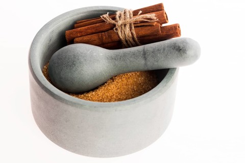 Cinnamon sticks with pure cane brown sugar in mortar