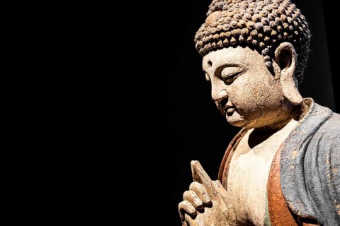 Buddha Statue, Concept of Zen, Spirituality, Peace. Copy space on Black Background, texture light