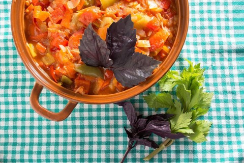 Closeup of delicious stew with mixed vegetables, arranged with green and purple leaves