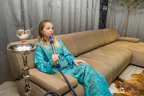 Woman smoking traditional Hookah (Narguile, Shisha, Chicha, Arguile), equipment used for smoking
