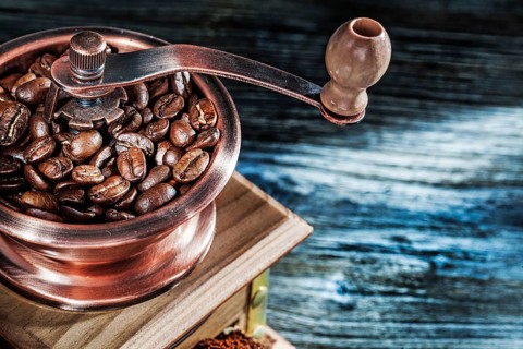 Coffee mill seeds on wooden board