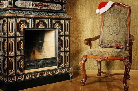 Old Antiques Armchair With Santa's Hat Near The Fireplace