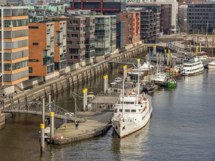 Harbour area with modern designed buildings along a canal. Boats and railings at the harbour,