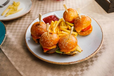 Mini burgers and fried potatoes on the table at party food. Finger food on catering