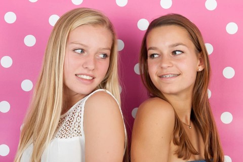 Teen girlfriends on pink background