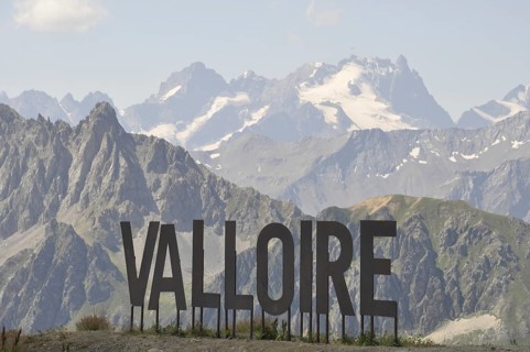 Name of Valloire write in metal letters, Valloire sign against a backdrop of majestic mountains and