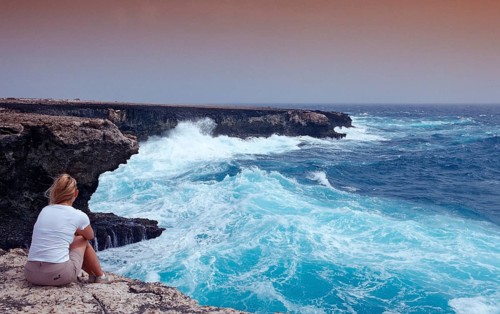 Woman watching storm on the coast, Netherlands Antilles, Bonaire, Caribbean, Caribbean Sea,