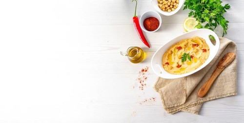 Hummus paste with lemon and chilli on a white background
