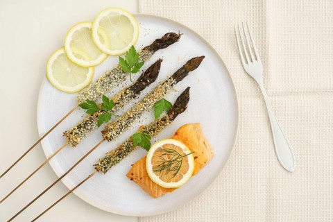 Panko-fried green asparagus on a skewer with salmon and lemon