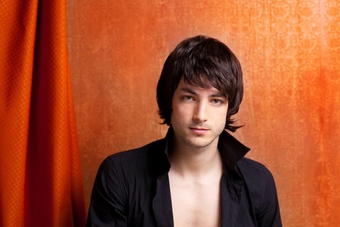 British indie pop rock look young man on orange brown retro background