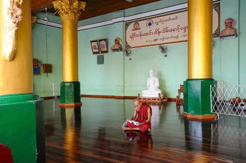 10.08.2013, Yangon, Myanmar, Asia, A Buddhist monk sits on the floor in the temple area of the