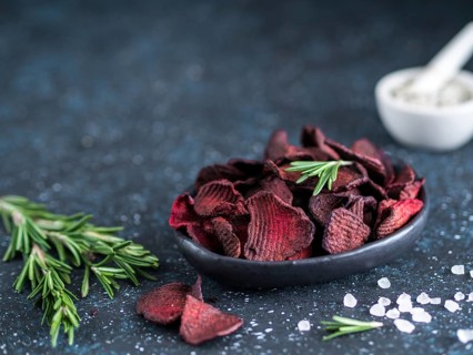 Baked beet slices with coarse sea salt scented rosemary. Vegan diet food idea and recipe. Healthy
