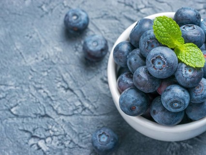 Freshly picked blueberries closeup. Ripe and juicy fresh blueberry with green mint leaves on