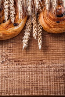Ripe wheat ears rich raisin baked goods on oaken wooden board food and drink concept