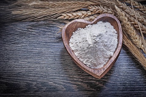 Composition of wooden bowl with flour golden rye wheat ears food and drink concept