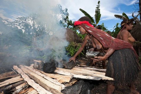 Dani Stamm heats stones for an earth oven, Baliem Valley, West Papua, Indonesia, Asia