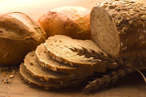 Close-up of a freshly baked loaf of bread with a wheat head