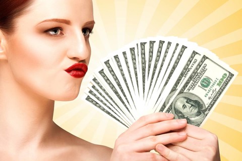 Creative portrait of a naked girl with beautiful face and body holding hand fan made of 100 dollar