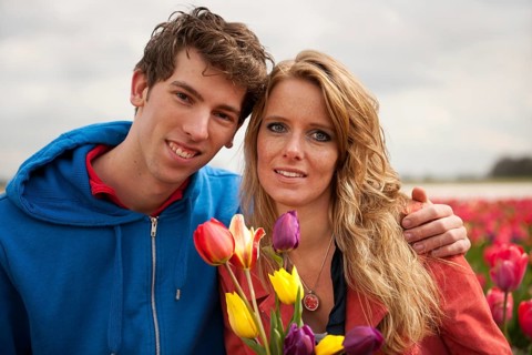 Young couple in Dutch flower fields with colorful tulips