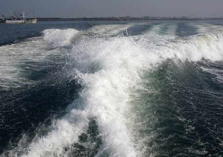 The engines of a powerful speedboat create a huge surf