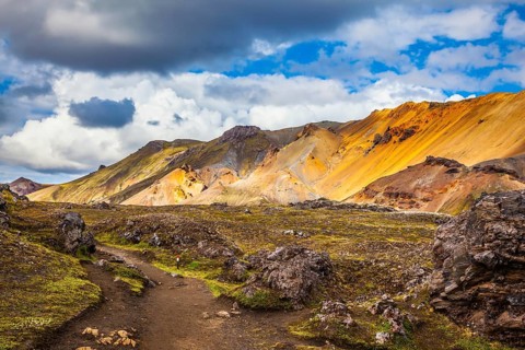 Travel to Iceland in July, volcanic summer tundra. Multi-colored rhyolite mountains - orange,