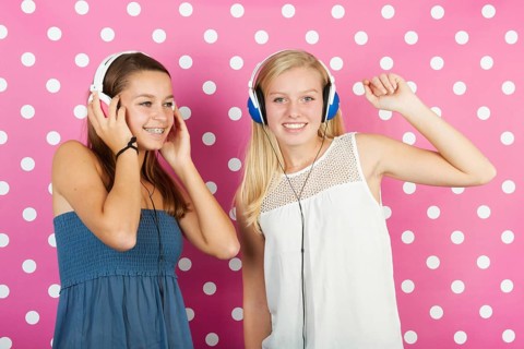 Two teenager girls listening to music with headphones