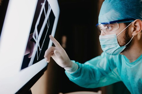 A surgeon analyzing data on a touch screen with concentration