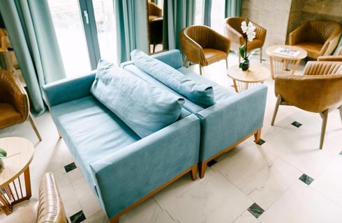 Bellagio, Italy - 07 june 2020: A large hall with blue sofas and pillows, with empty tables and