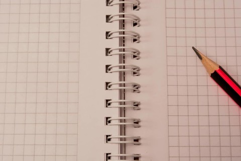 White empty notebook with pencil on top of it