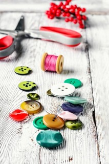 Thread, buttons, beads and scissors on the table light vintage