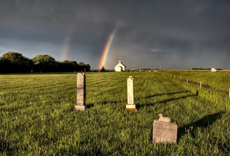 Old Country Church in Saskatchewan Canada with storm clouds rainbow