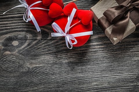 Present box red hearts on vintage wooden board holidays concept