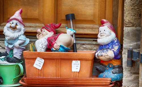 Garden gnomes in front of a door in a French village, 2019