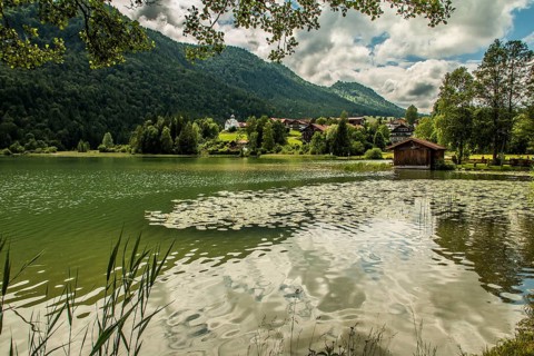 View over the Weissensee lake near Füssen in the Ostallgäu district to Oberkirch with the church of