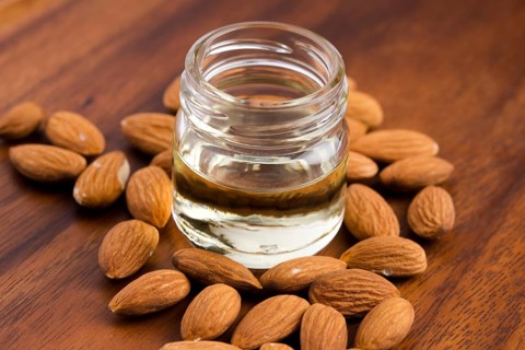 Almond oil with nuts on wooden background, lodz, poland