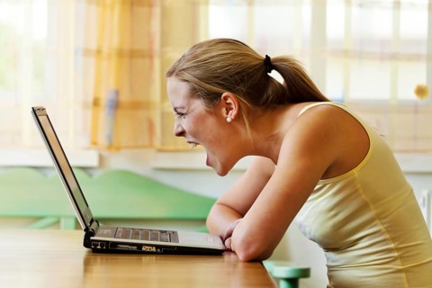 A woman is annoyed with her computer. Problems with hardware, software and internet shopping