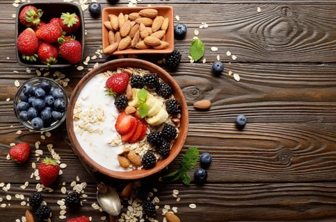 Flat lay top view at Fruit healthy muesli with banana strawberry almonds and blackberry with yogurt