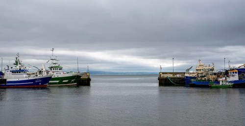 Greencastle, Ireland, 9 July, 2022: colorful fishing boats and trawlers in the sheltered port and