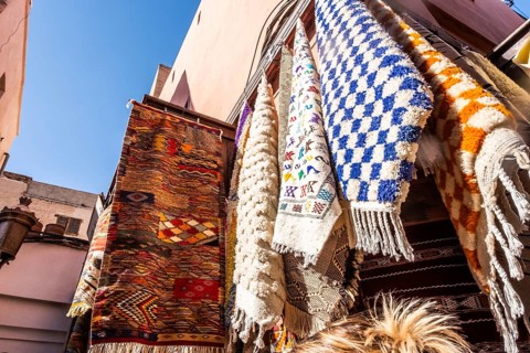 Colorful yellow, blue, red and green carpets in a shop in a souk in Marrakech. Morocco