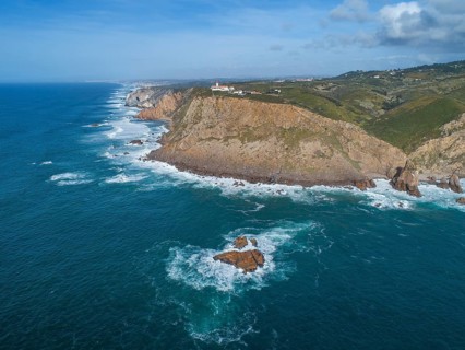 Aerial view of lighthouse at Cape Roca (Cabo da Roca) at sunset, the westernmost point of