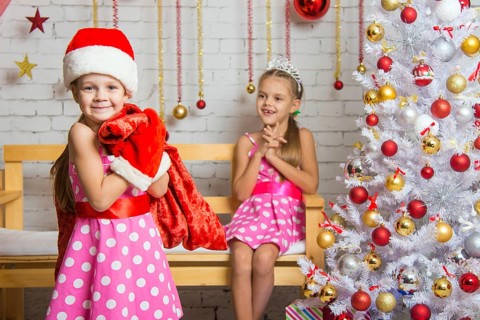 Two funny sisters four girls and six years of playing and having fun in the home New Years interior