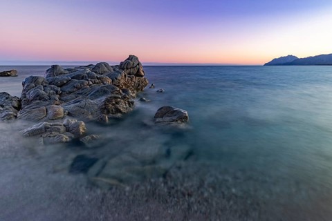 Rocks in the sea on the beach of Torre di Bari at sunset, long exposure, Torre di Bari, Bari Sardo,