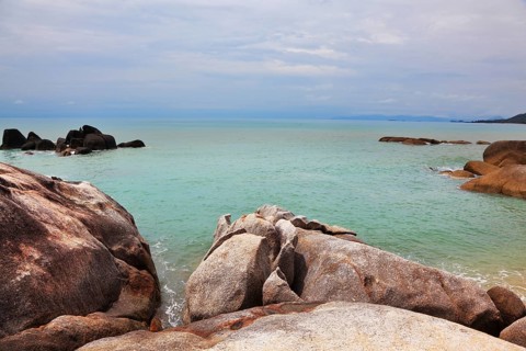Picturesque coastal cliffs and quiet after a storm sea. Koh Samui