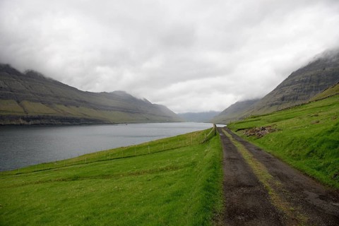 Gravel street on the Faroe Islands with the village Hvannasund in the background, Hvannasund, Faroe